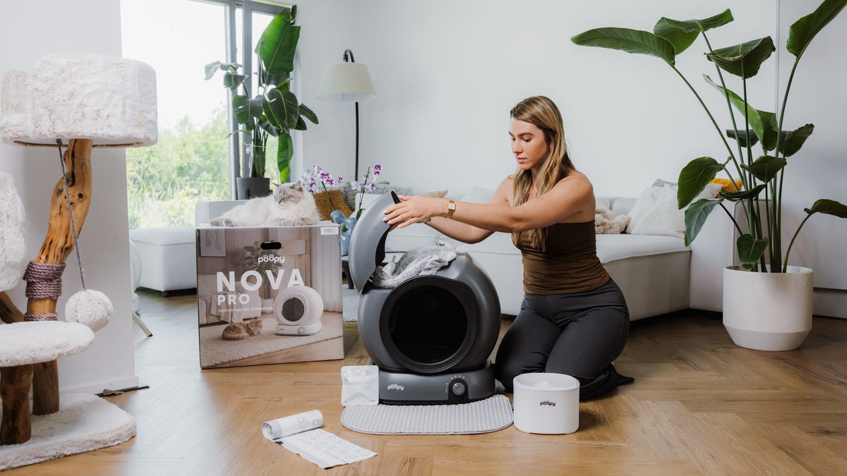 Vrouw pakt de Poopy Nova Pro uit met afvalzakjes en toebehoren in de woonkamer